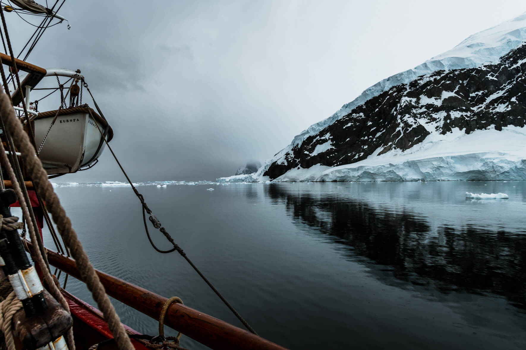 Tall ship Bark Europa and glacier landscape of Antarctica