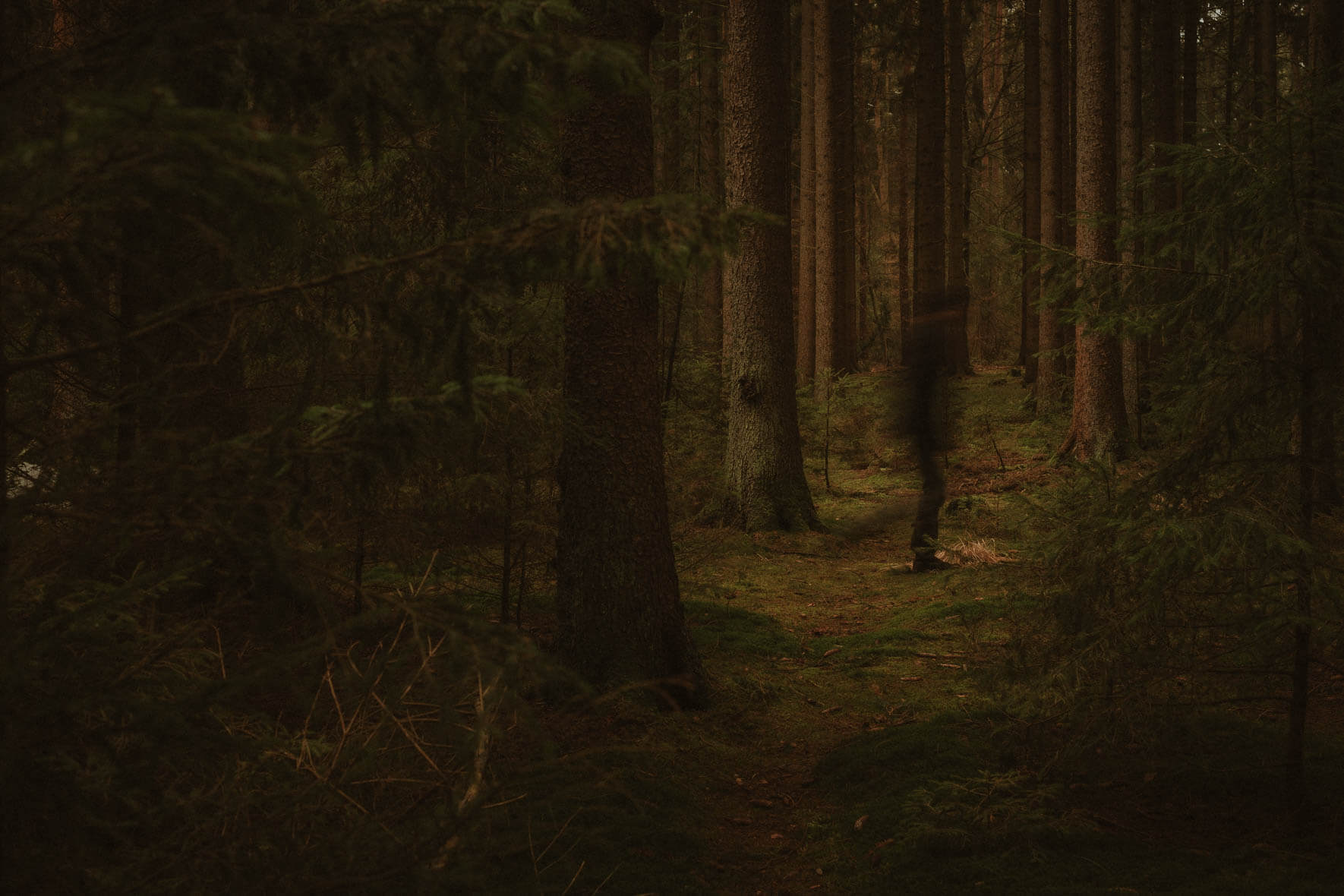 A man runs through a dark forest