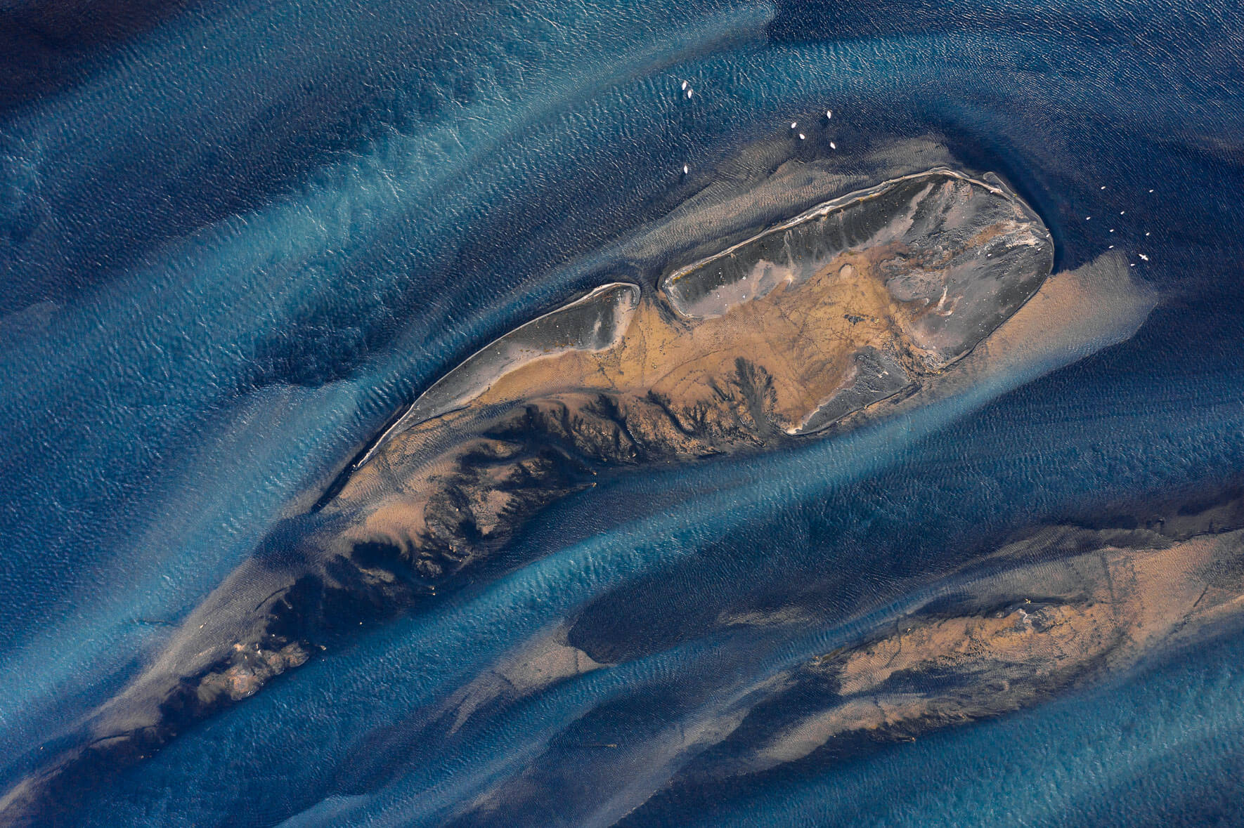 Abstract colors of Holsa river on the south coast of Iceland with small sandbanks and seagulls