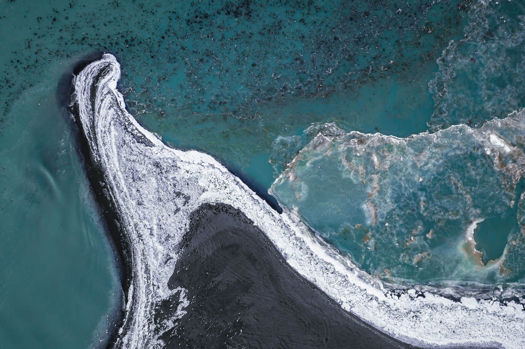 Turquoise colored glacier river in winter with frozen river banks