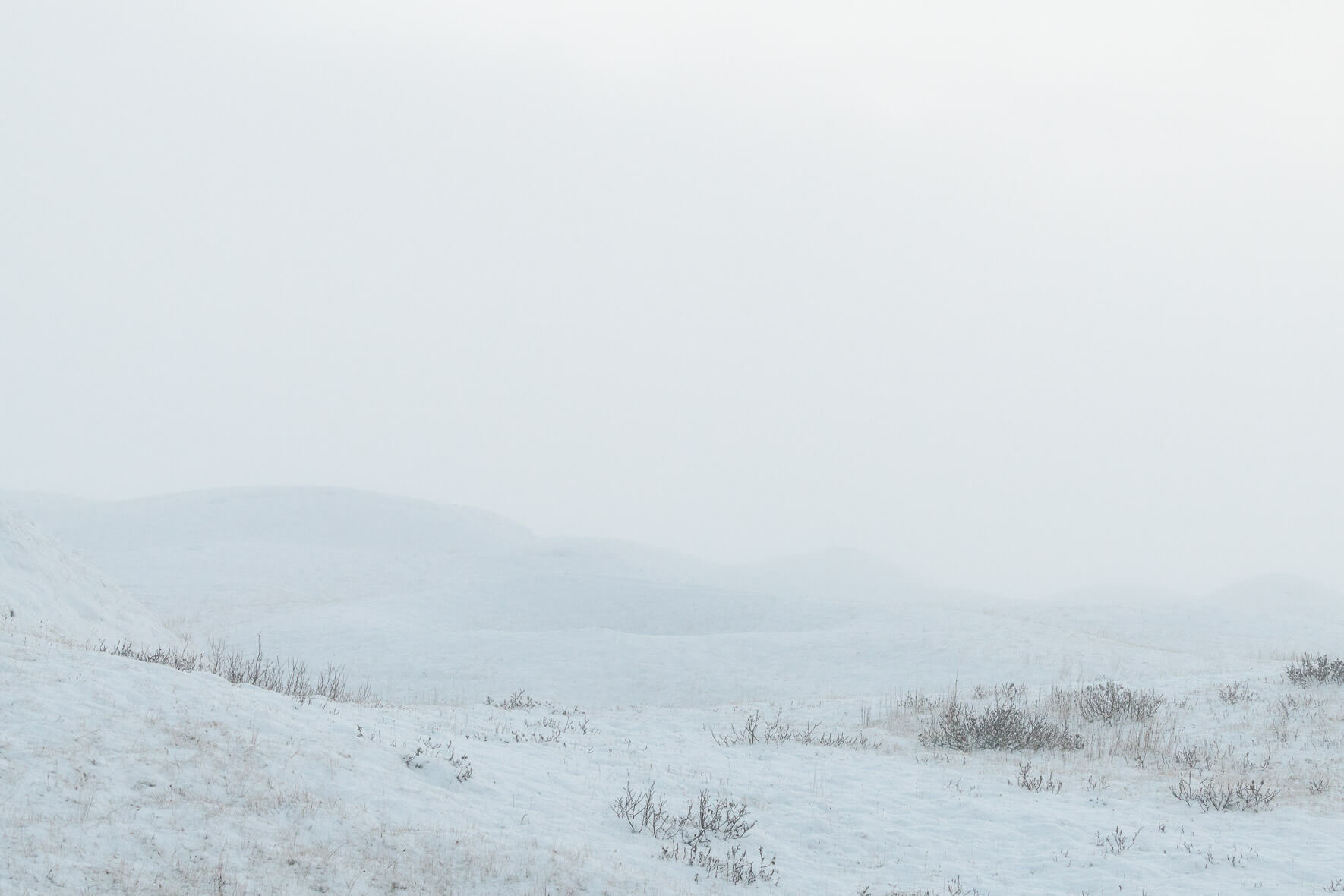 Minimalist scene with snow covered hills in winter fog
