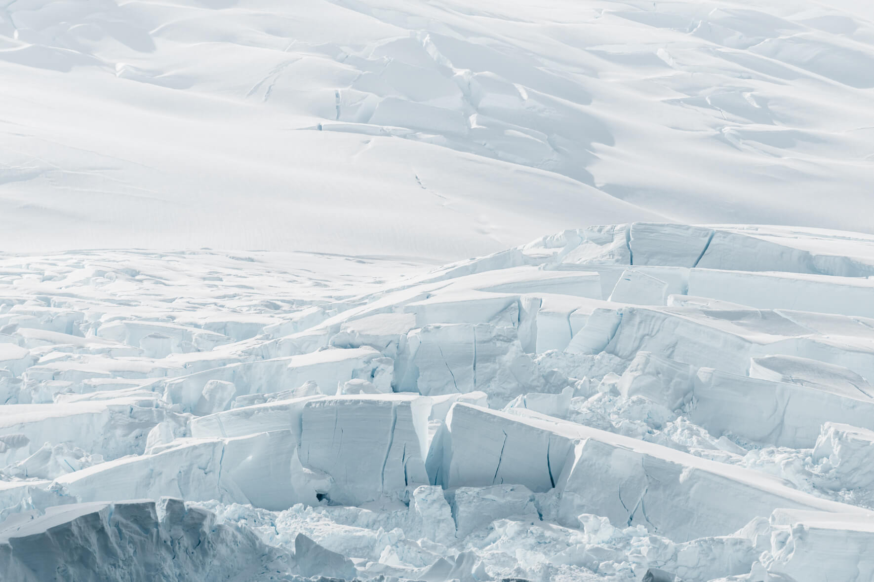 Glacier in Antarctica with huge crevasses in bright sunlight