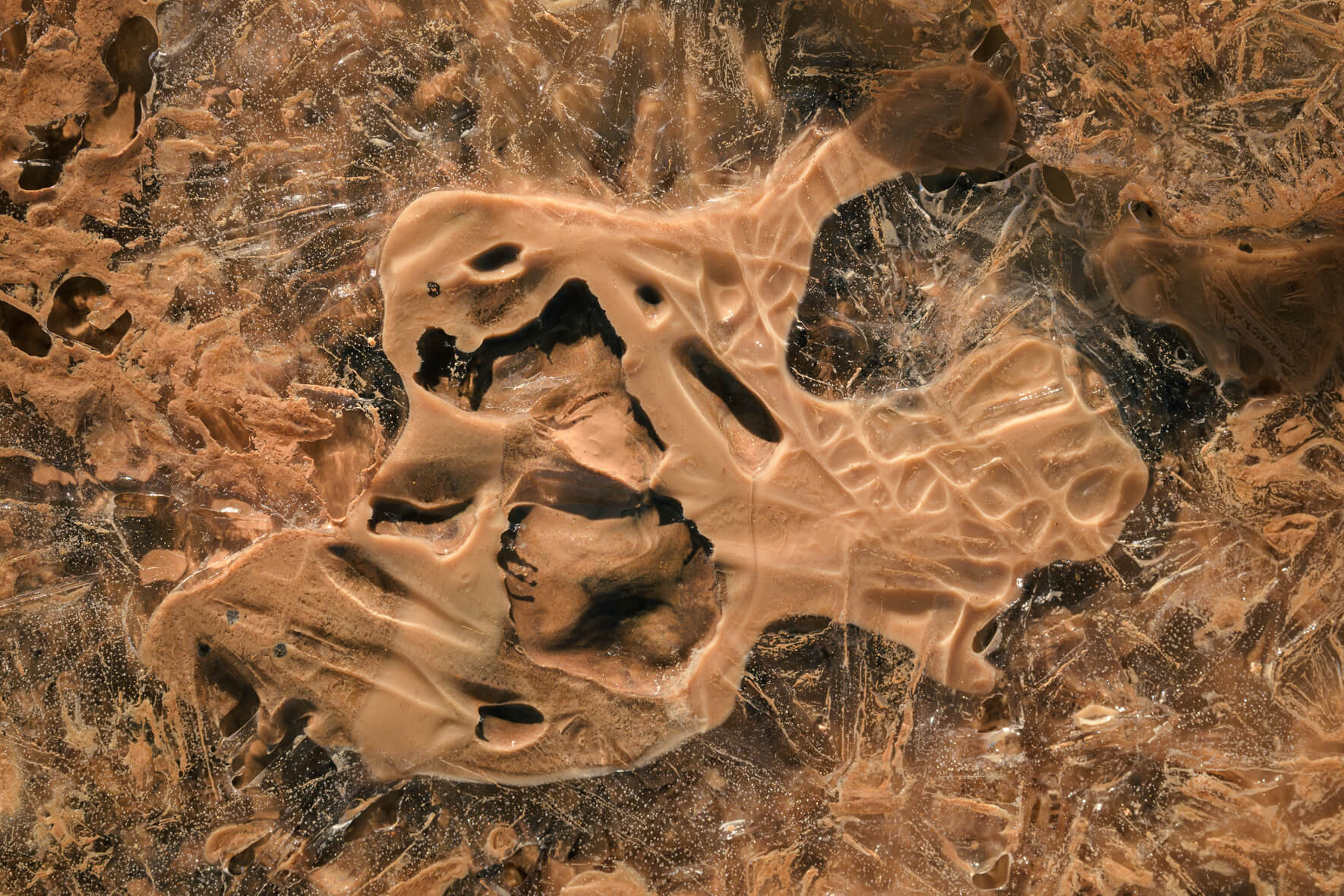 Abstract ice crystals in a frozen puddle in the Námafjall geothermal area near lake Myvatn, Iceland
