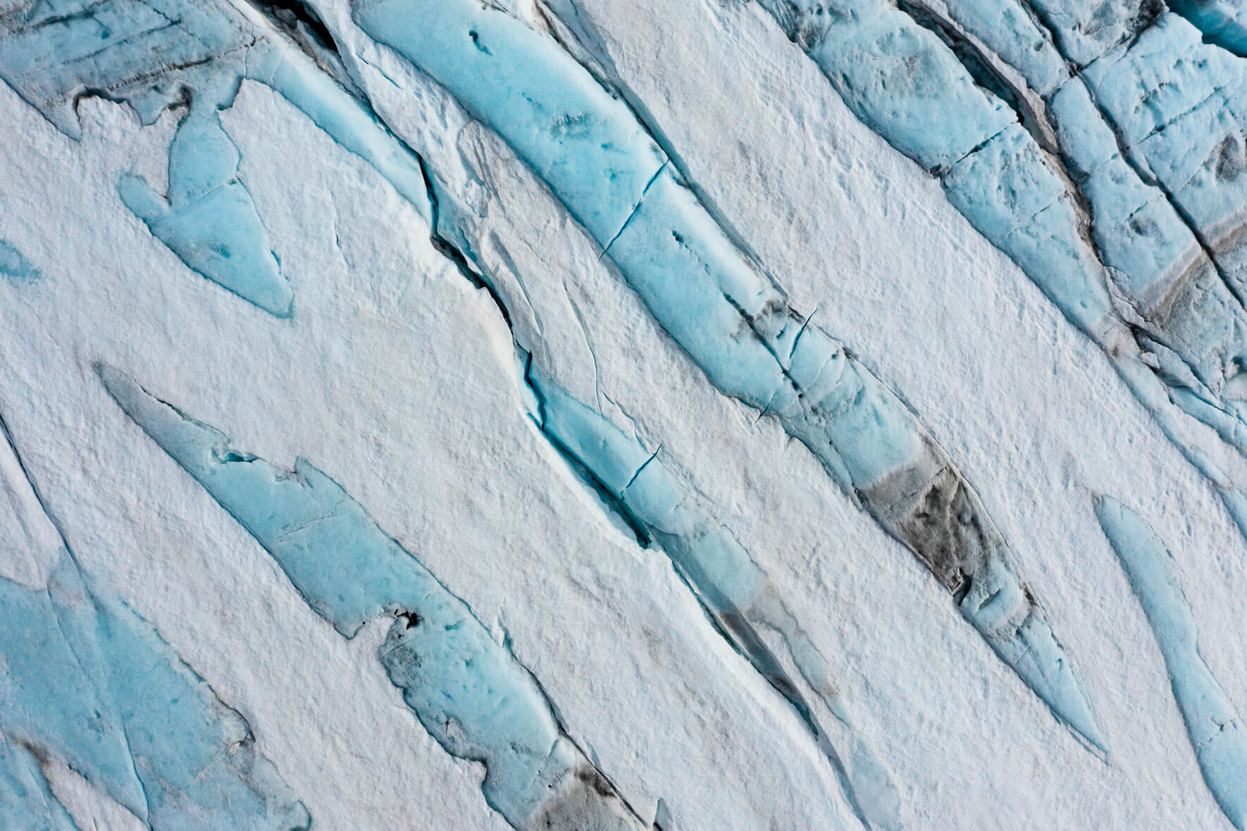 Aerial view of a snow-covered glacier in Norway with blue glacier ice