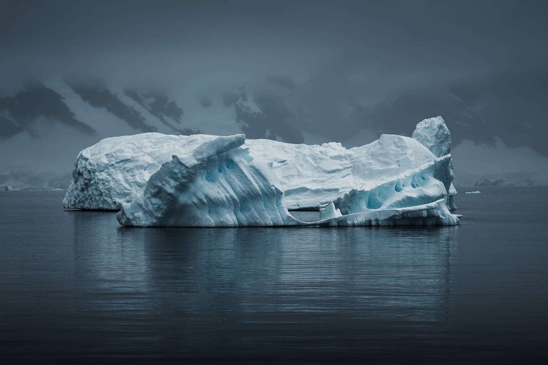 Reflections of an Iceberg in Antarctica in dark and moody weather