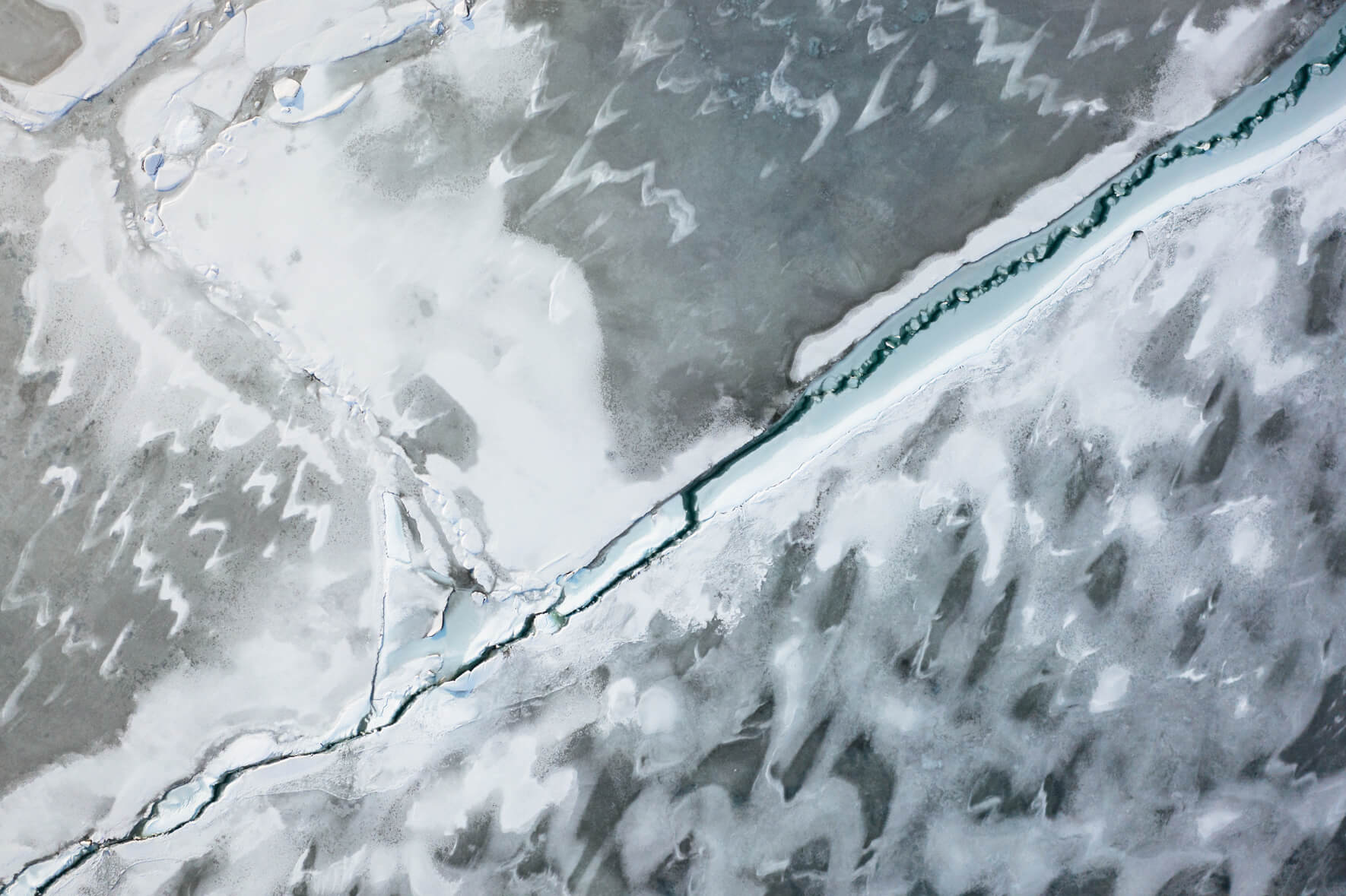 Aerial view of frozen glacier lagoon Jökulsárlón with abstract cracks in ice