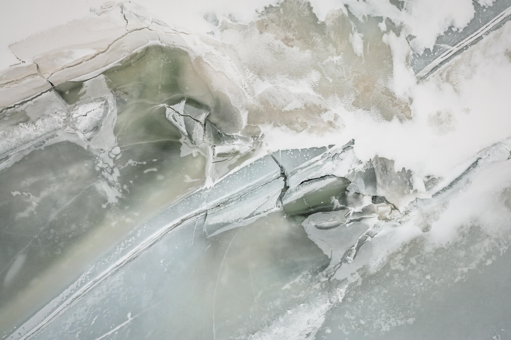 Aerial view of frozen lake Åraksfjorden in Southern Norway with massive cracks in the surface and ice floes