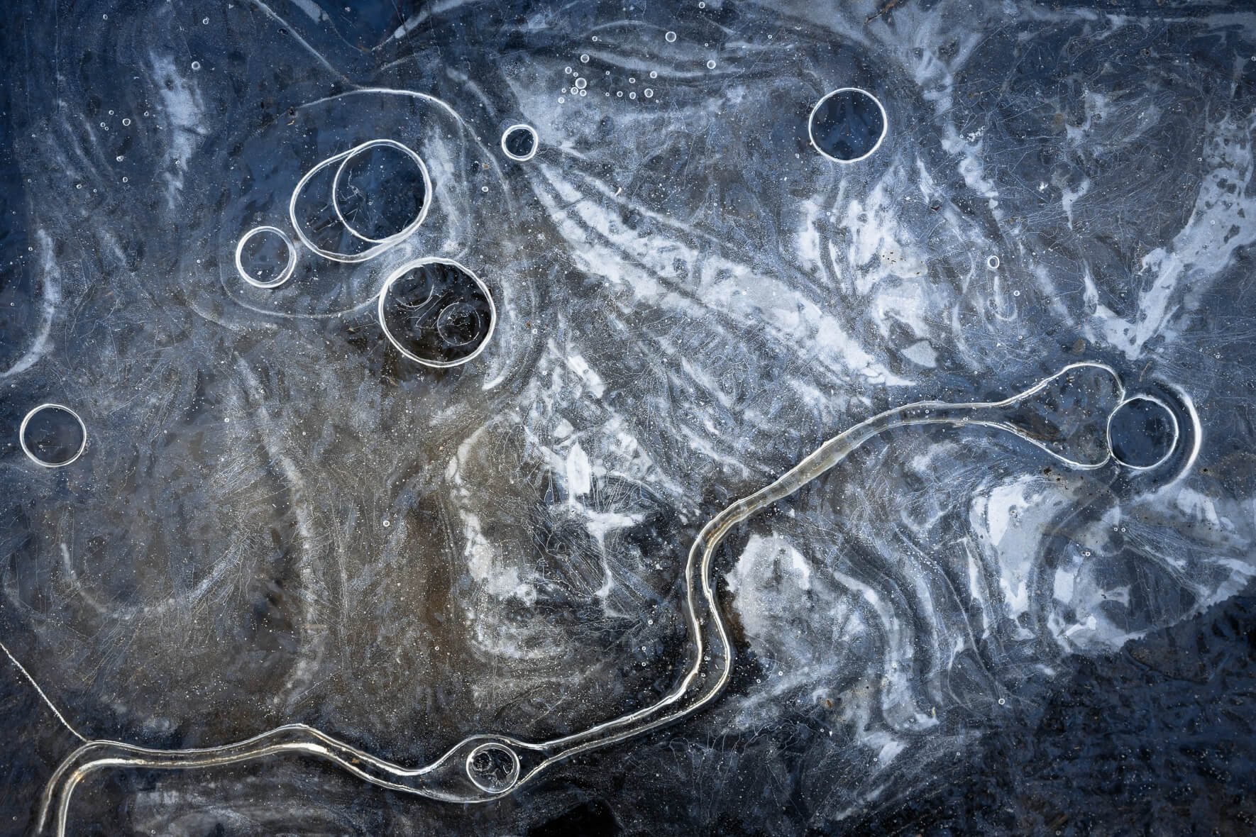 Macro details of a frozen stream with air bubbles