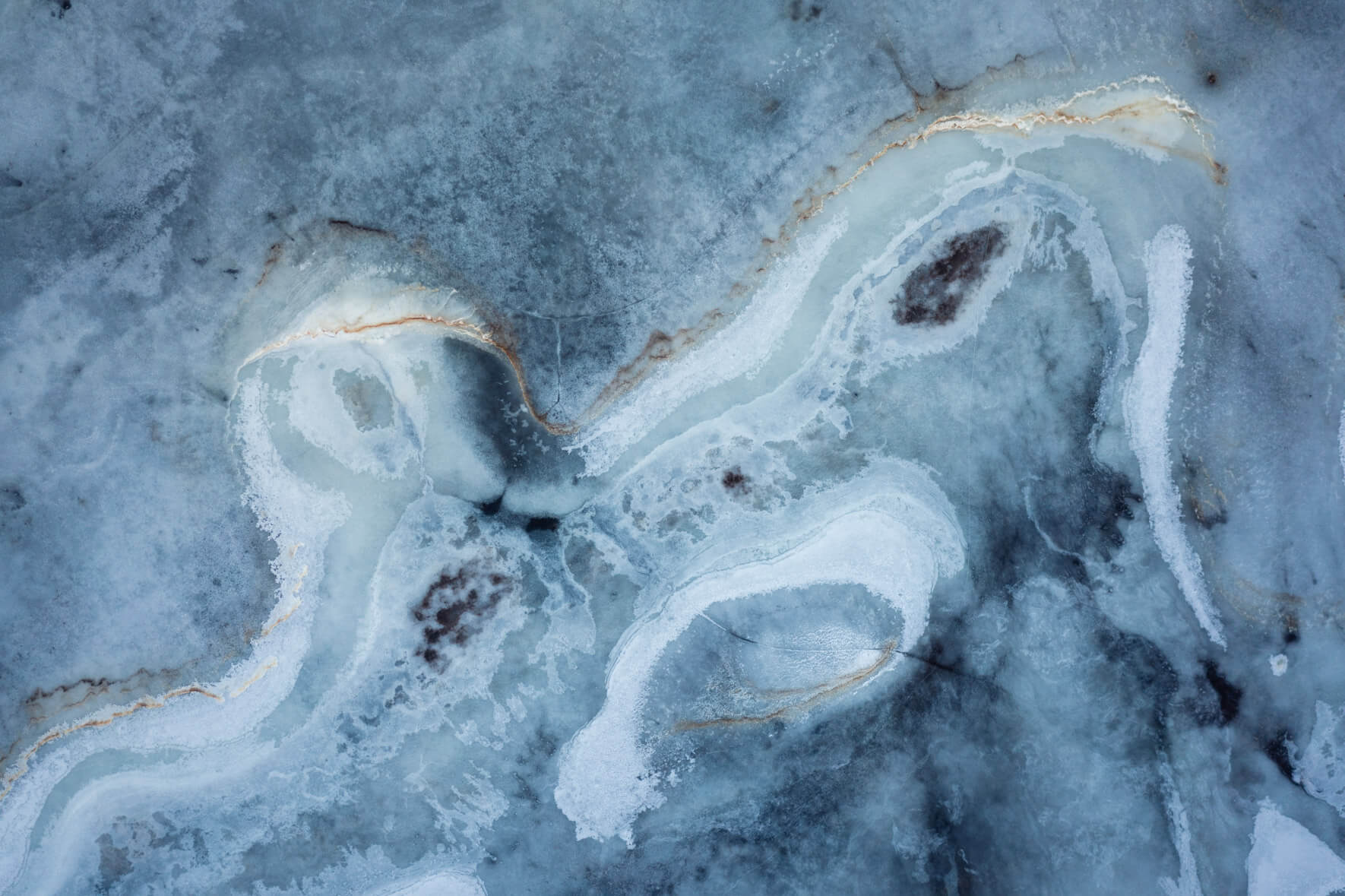 Aerial abstraction of Iceland’s marshlands, where ice and organic matter intertwine