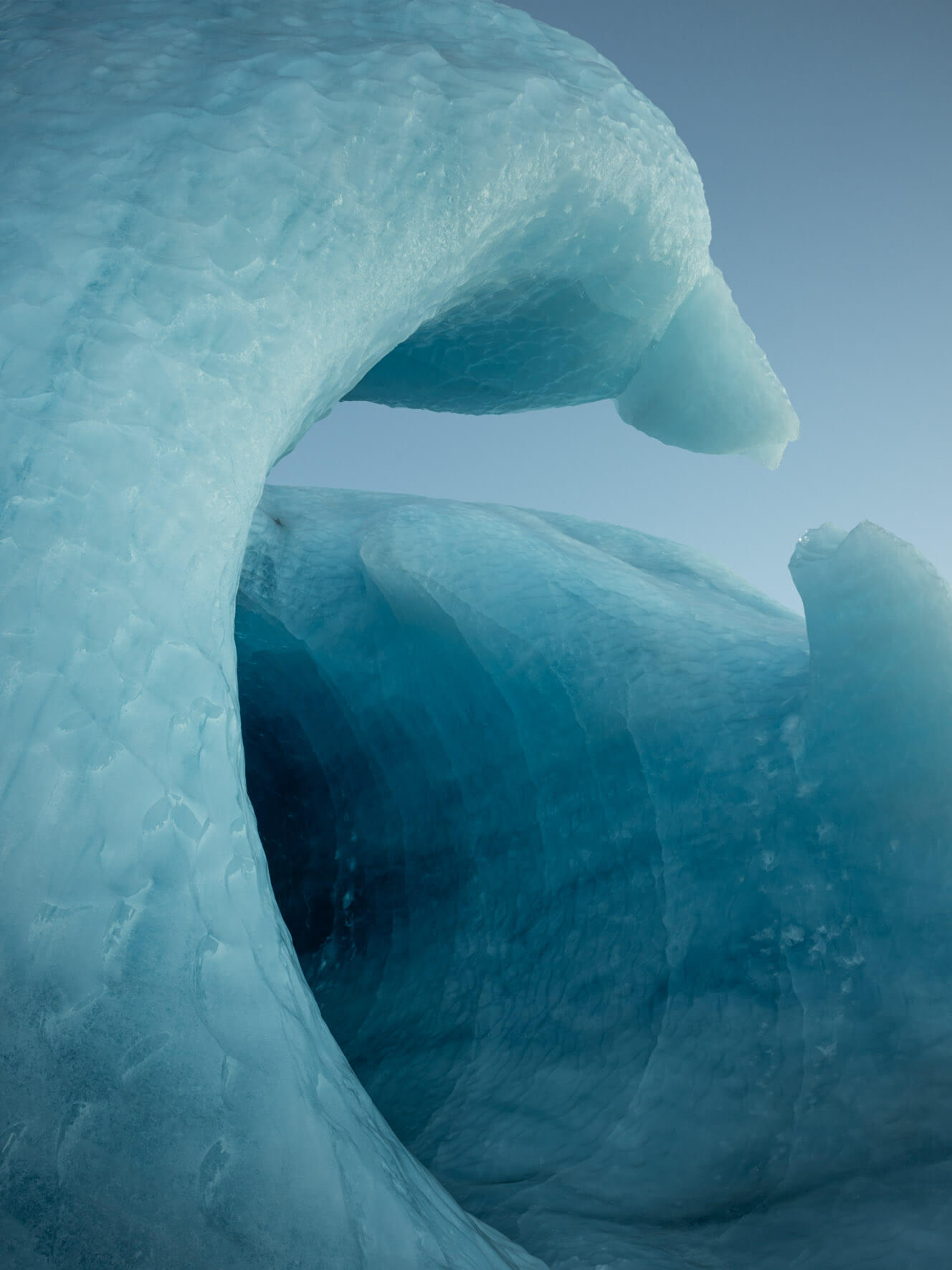 Grand ice entrance resembling an architectural sculpture, leading into a frozen world