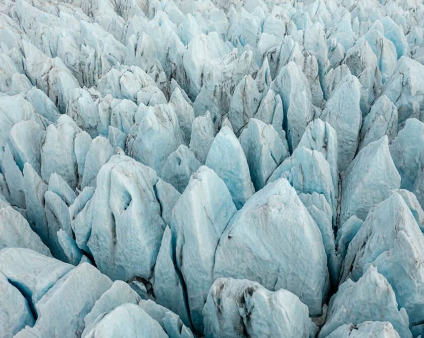 Aerial view of a glacier in Iceland with glacier towers and deep crevasses
