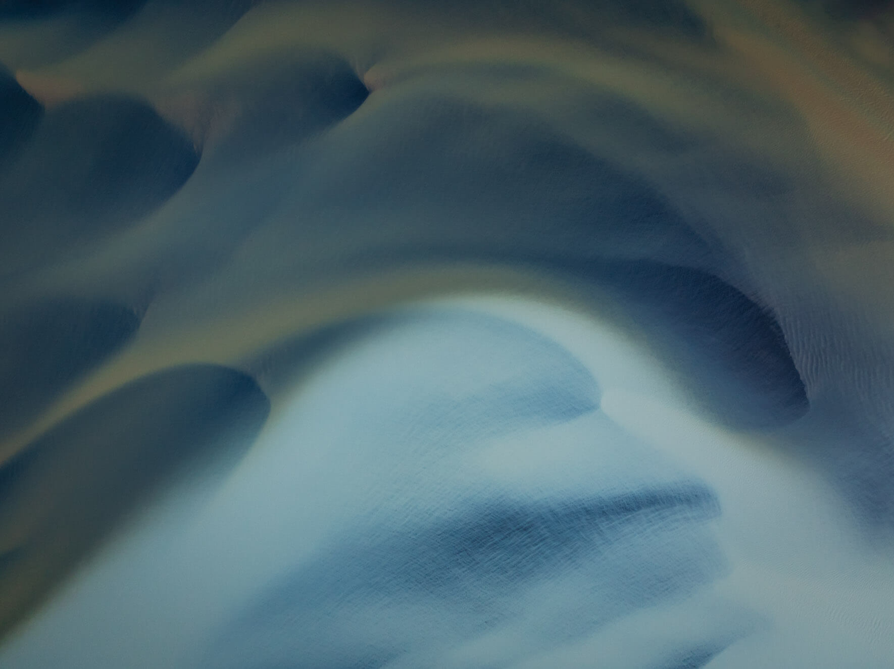 Aerial view of mineral-rich waters near Iceland’s coast blending pale and yellow tones