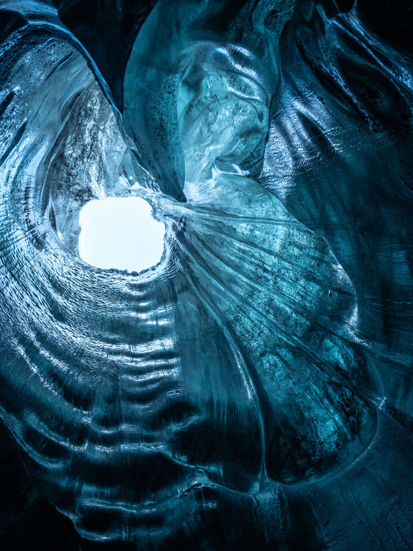 A hole in the ceiling of a cave in a glacier in Iceland