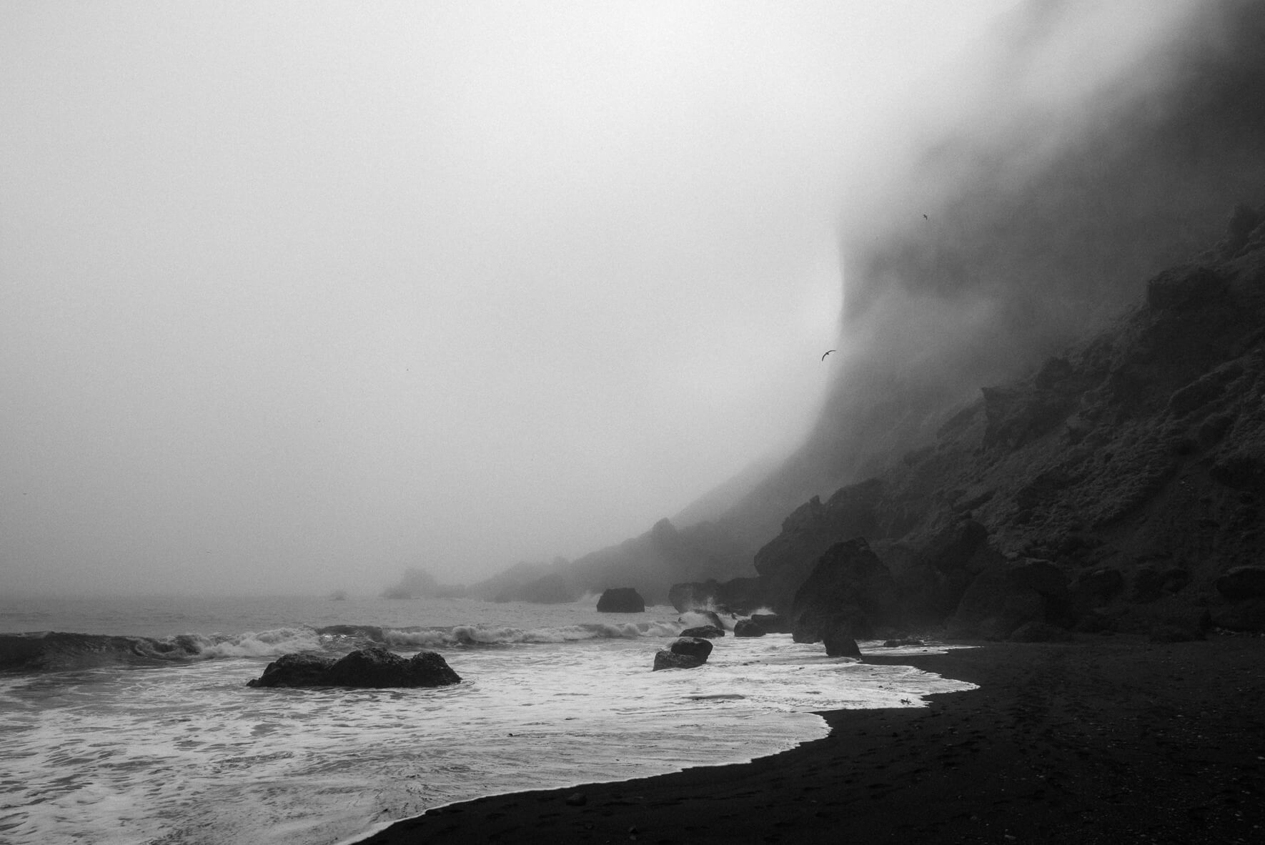 Foggy weather over the black sand beach of Vík í Mýrdal in Iceland in black and white
