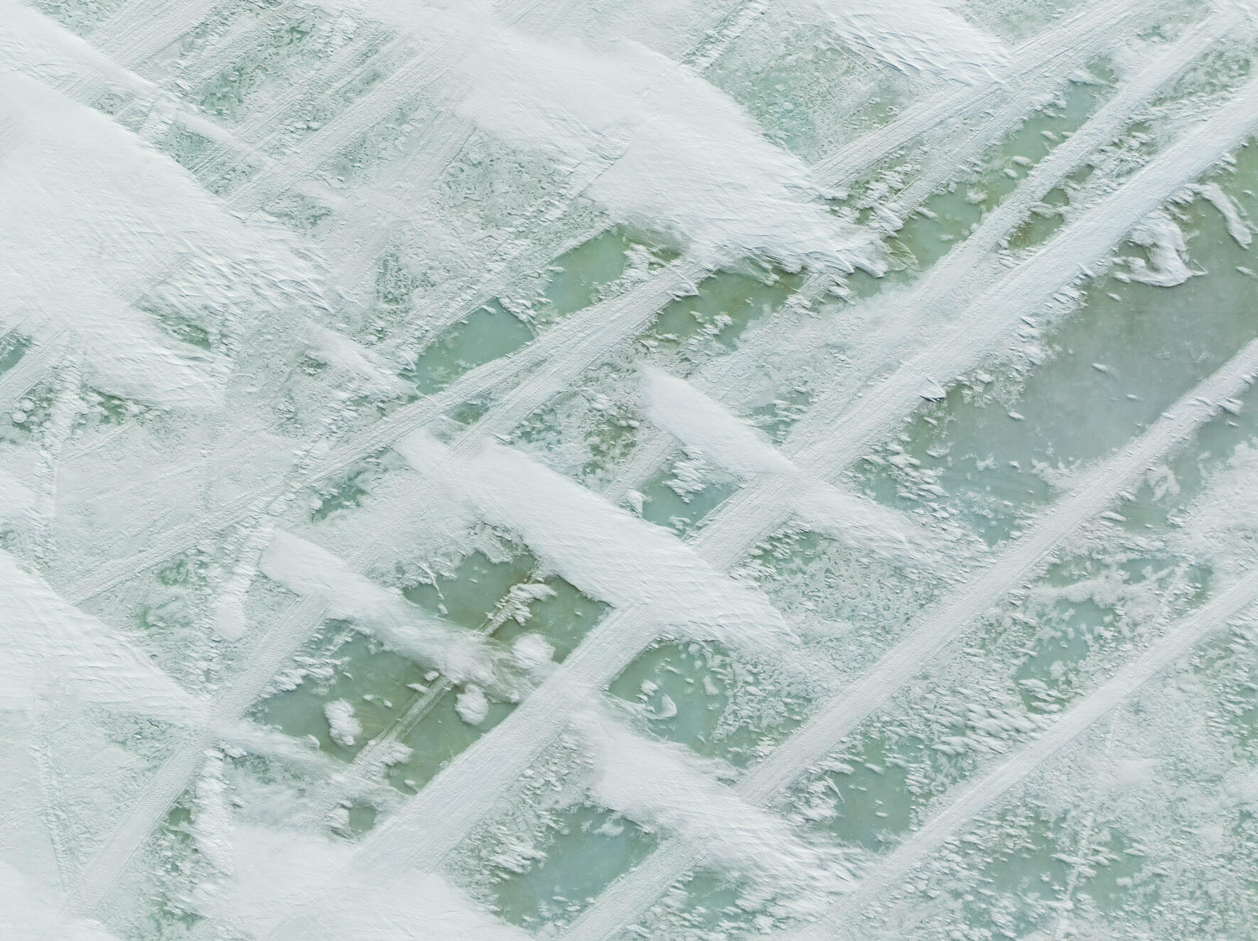 Snow and ice compositions on a frozen lake in Norway’s Hardangervidda plateau seen from above