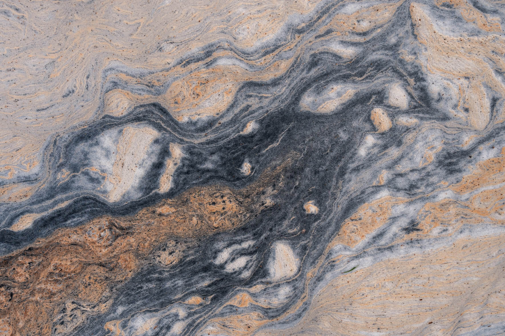Intricate patterns of flower pollen floating on a small creek in Norway