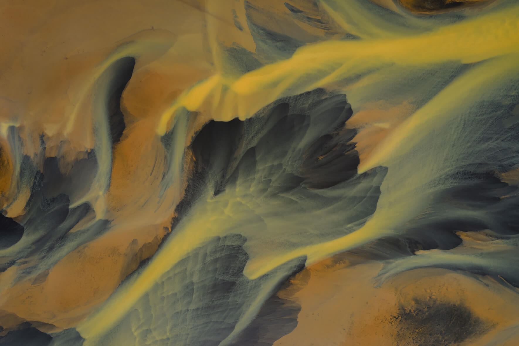 Aerial view of Icelandic river with mineral-yellow flows over dark terrain