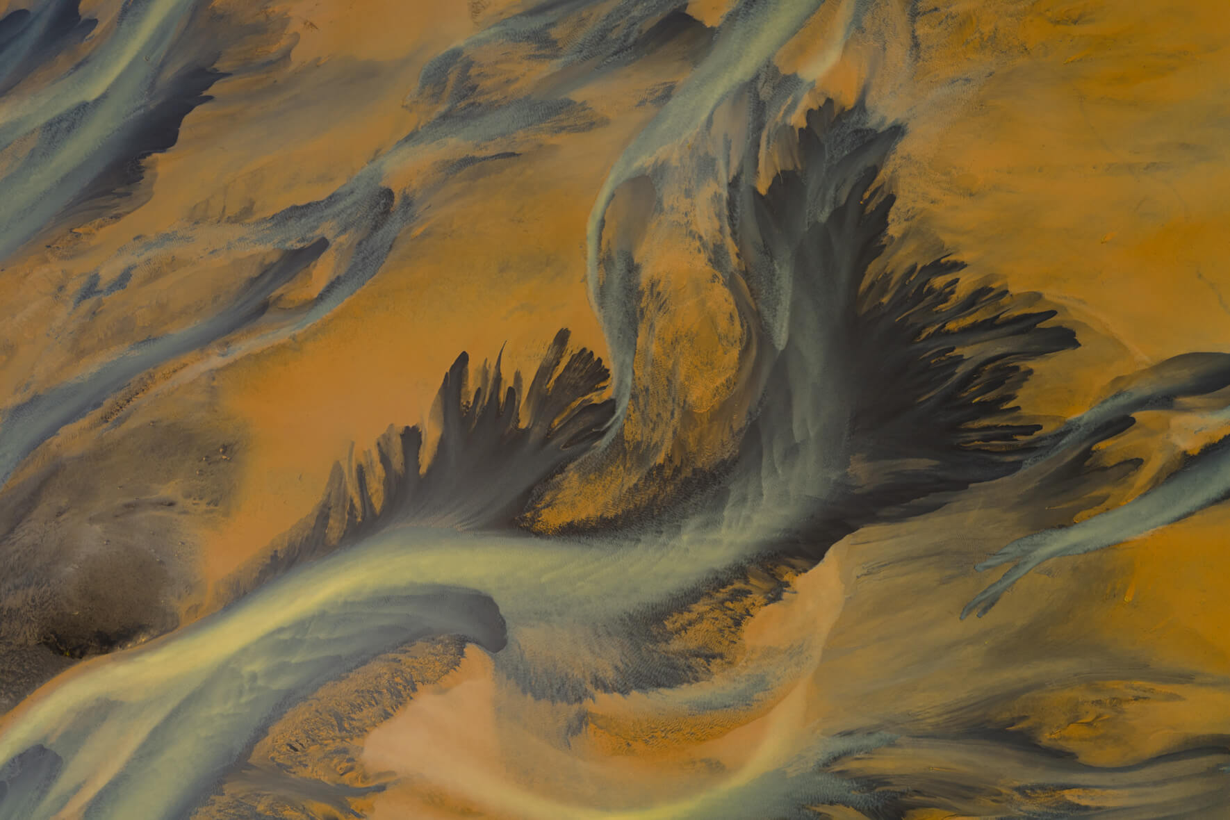 Aerial view of sulphur-rich river delta in Iceland with golden geothermal tones