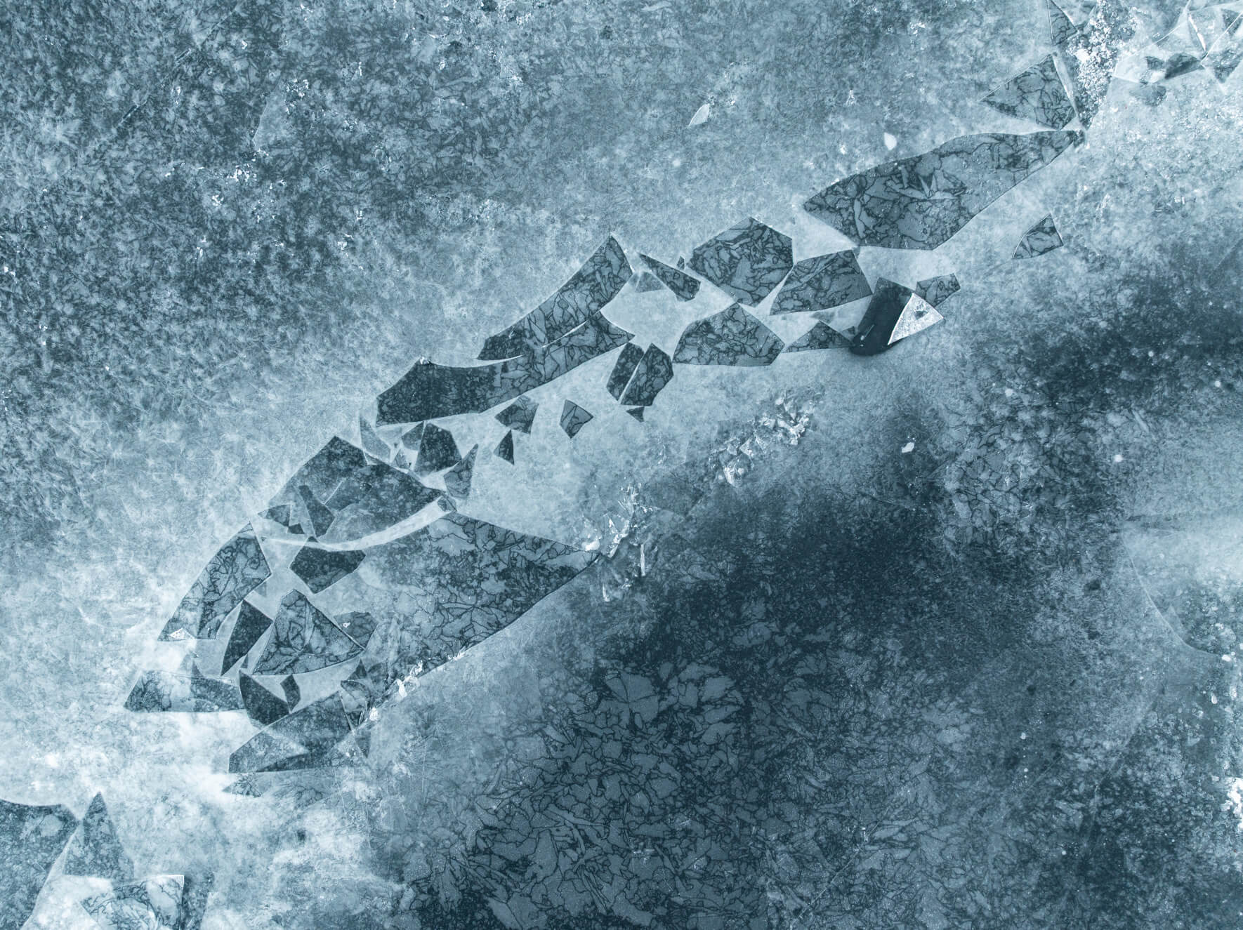 Aerial winter view of frozen lake with abstract shapes and ice floes
