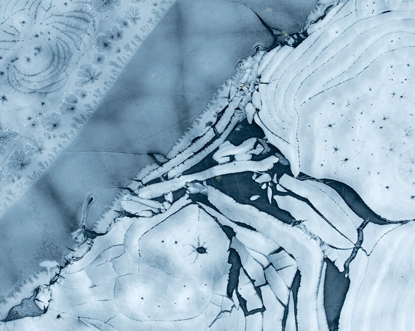 Frozen lake surface with textured ice formations and deep blue tones