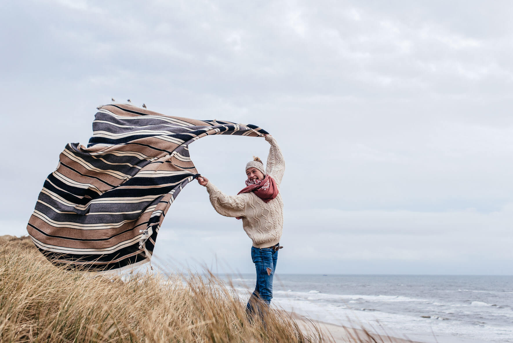 Woman with blanket on a beach in Denmark