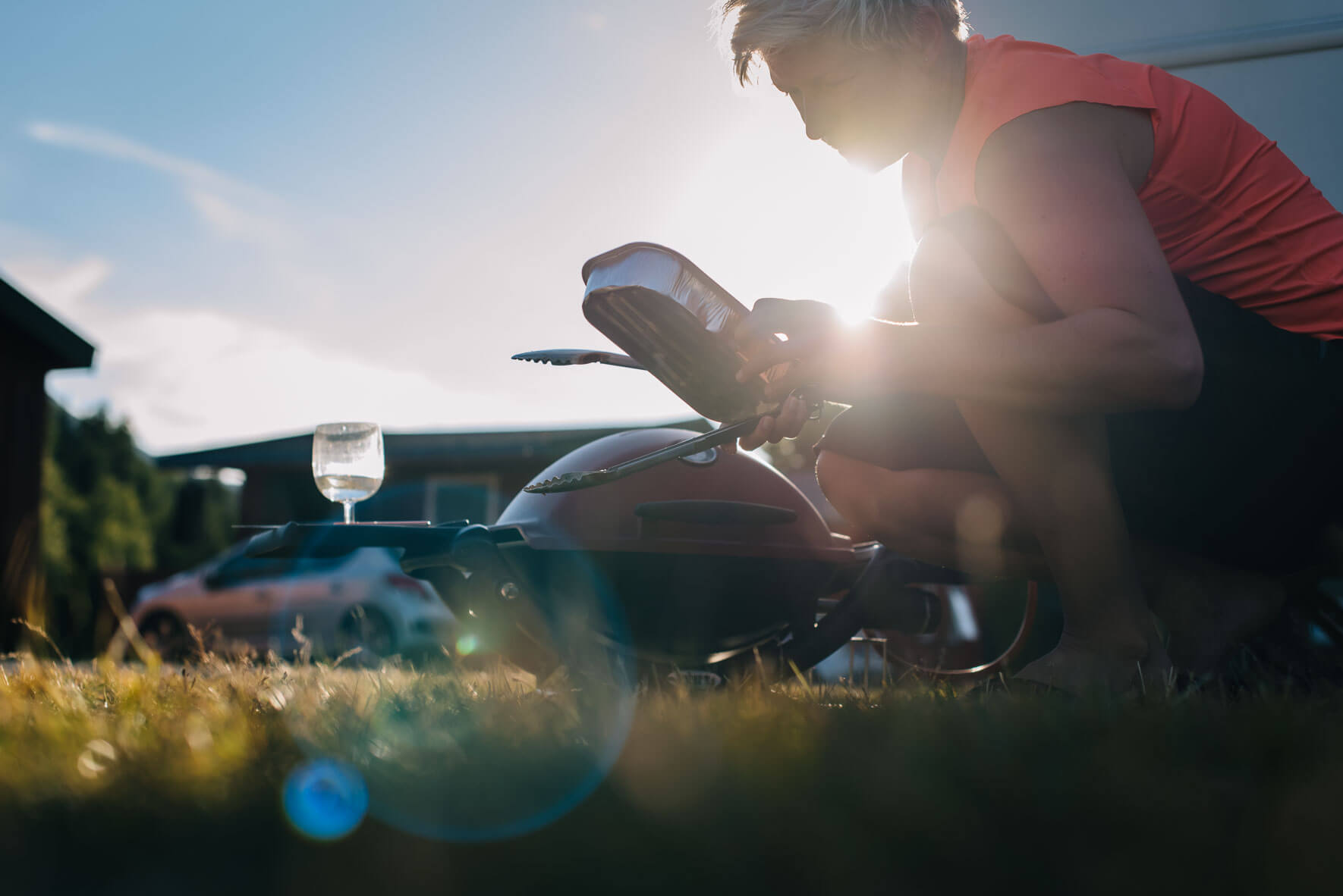 Woman on a campsite with red Weber Q 1200 grill