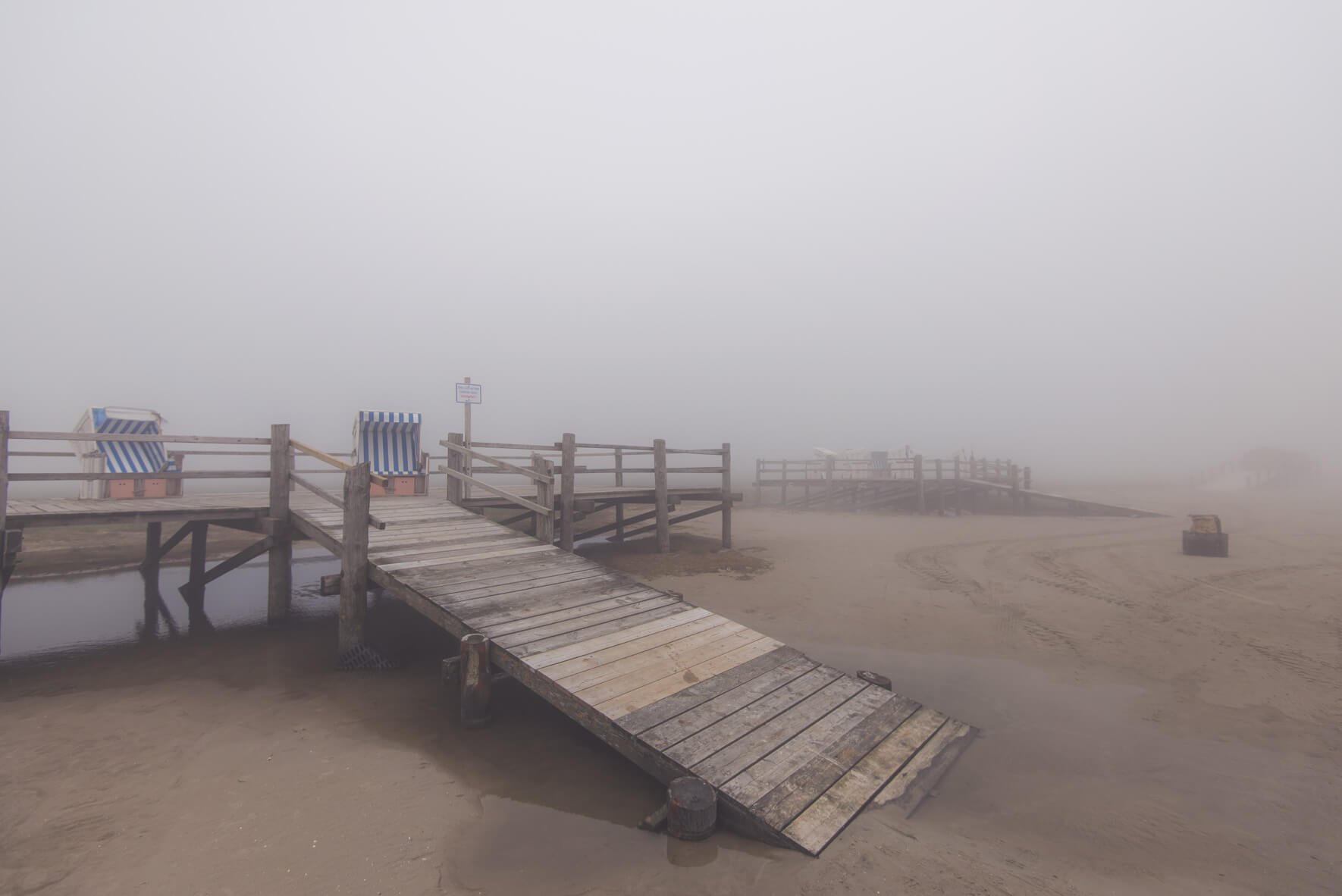Beach chairs on the beach of Sankt Peter-Ording in thick fog